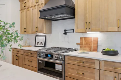 a kitchen with granite countertop white cabinets and stainless steel appliances