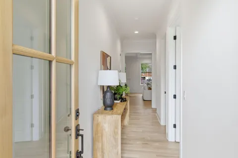 a view of a hallway with wooden floor windows and a livingroom