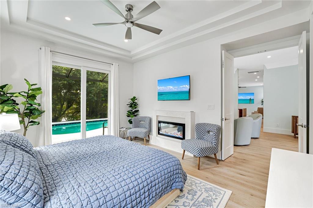 2515 Royal Palm Court Naples, FL 34103 - Photo 16 of 32 a bedroom with a bed and a fireplace