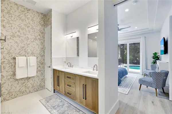 a spacious bathroom with a double vanity sink a mirror and a bathtub
