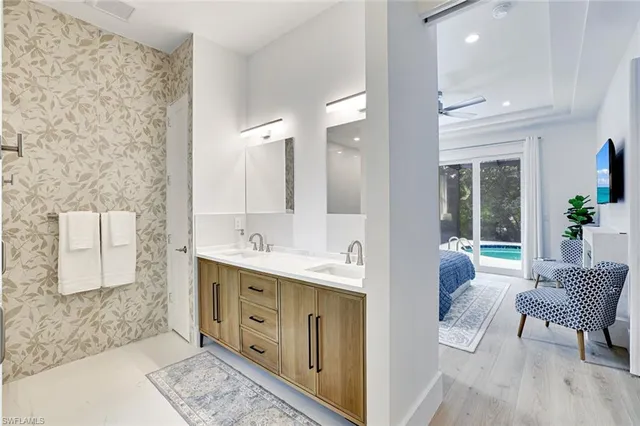 a spacious bathroom with a double vanity sink a mirror and a bathtub