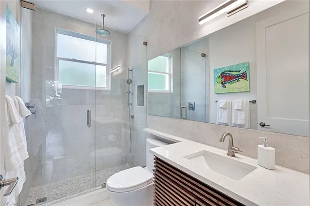 a bathroom with a sink a toilet a shower and a mirror