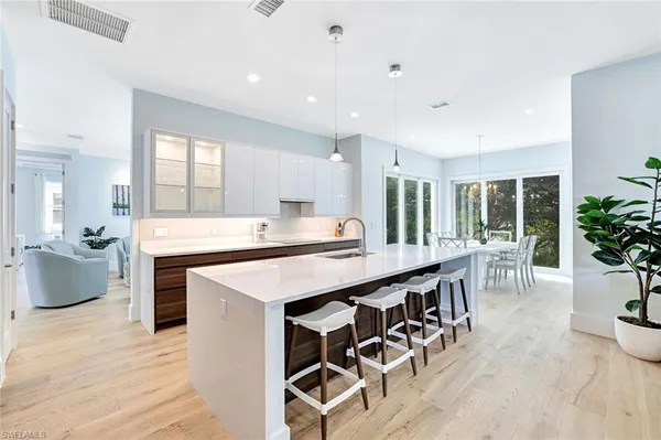 a large kitchen with counter space a sink appliances and dining table