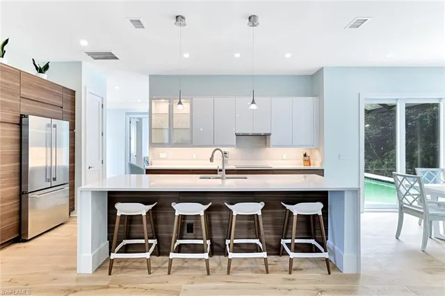 a kitchen with granite countertop a counter space chairs stainless steel appliances and cabinets