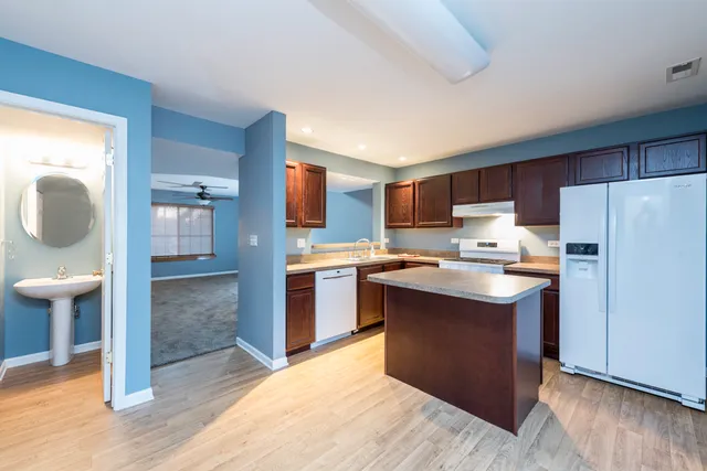 a kitchen with refrigerator cabinets and wooden floor