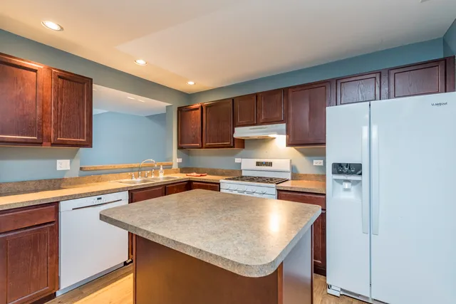 a kitchen with stainless steel appliances a refrigerator a sink and a stove