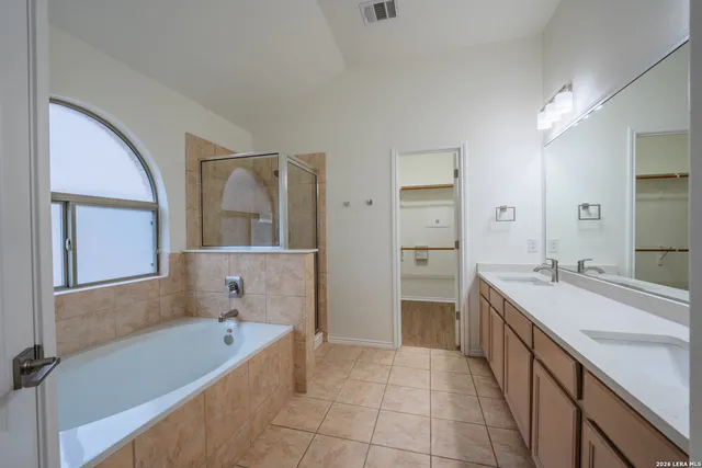 a bathroom with a tub sink and mirror