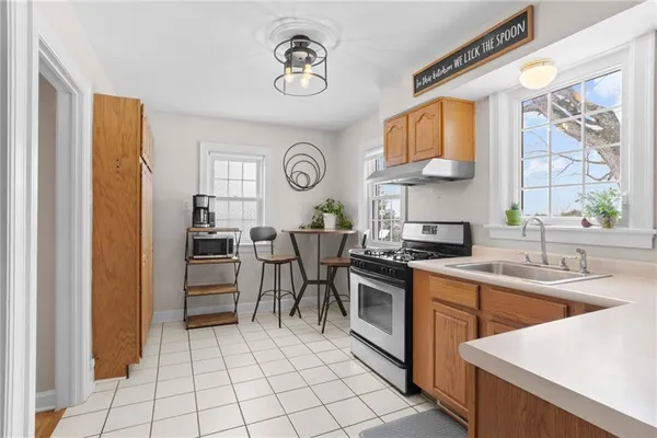 a kitchen with stainless steel appliances a stove a sink and a refrigerator with wooden floor