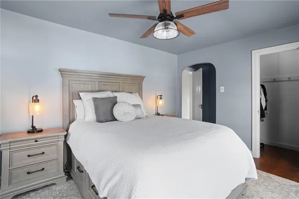 a bedroom with a bed and a painting on the wall