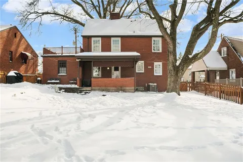 a view of a house with a yard covered in snow