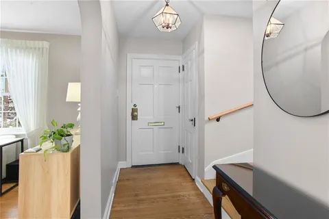 a view of a room with wooden floor and a chandelier