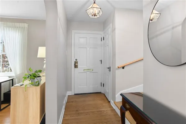 a view of a room with wooden floor and a chandelier