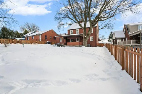 a front view of a building with large trees