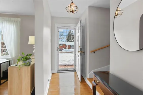 an entryway with a flower pot and a bookshelf