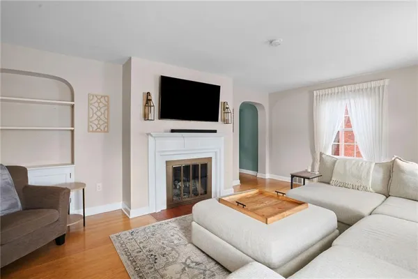 a living room with furniture a flat screen tv and a fireplace