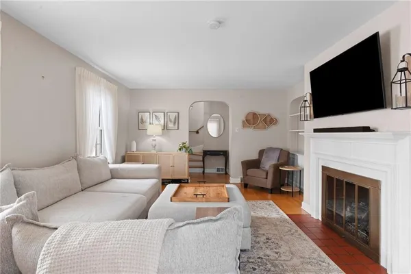 a living room with furniture a fireplace and a flat screen tv