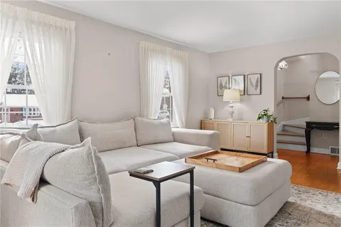 a living room with furniture a large window and potted plants
