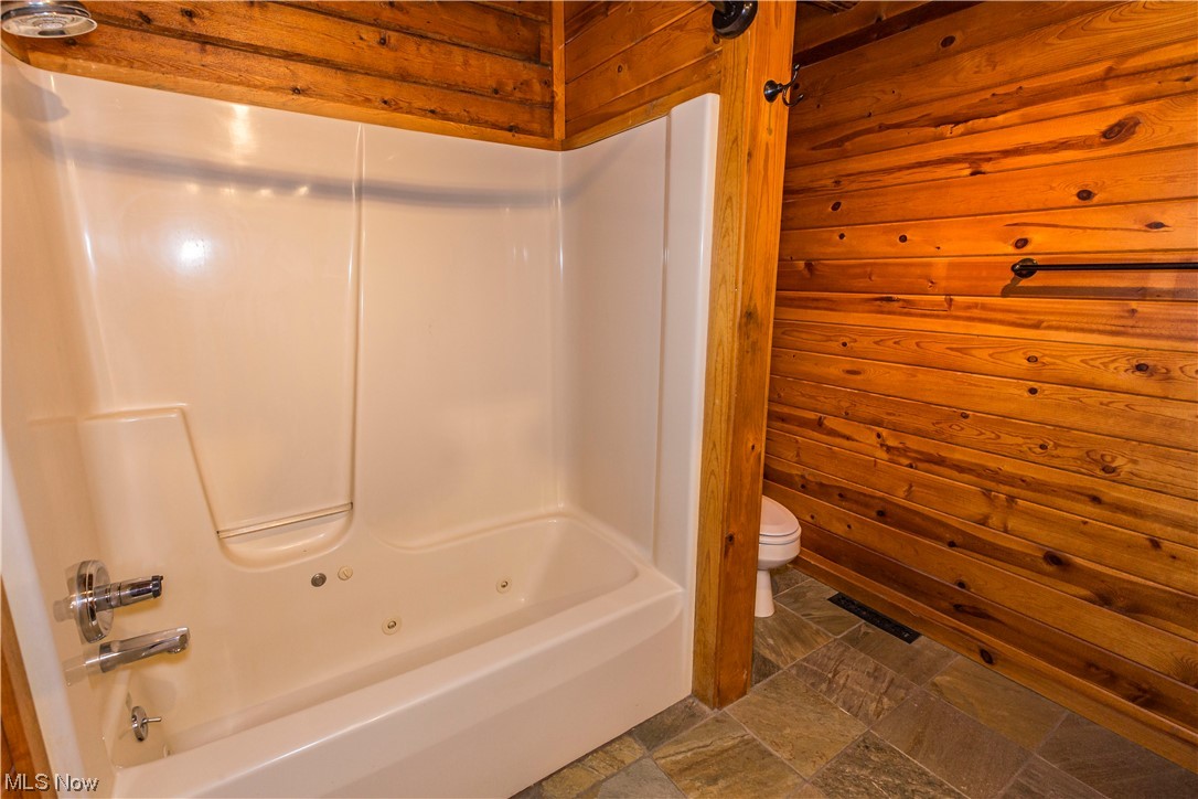 4069 Erhart Road Medina, OH 44256 - Photo 14 of 30 Bathroom with wooden walls, shower combination, toilet, and tile flooring