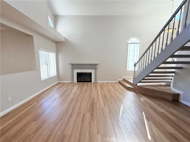 a view of empty room with wooden floor and fireplace