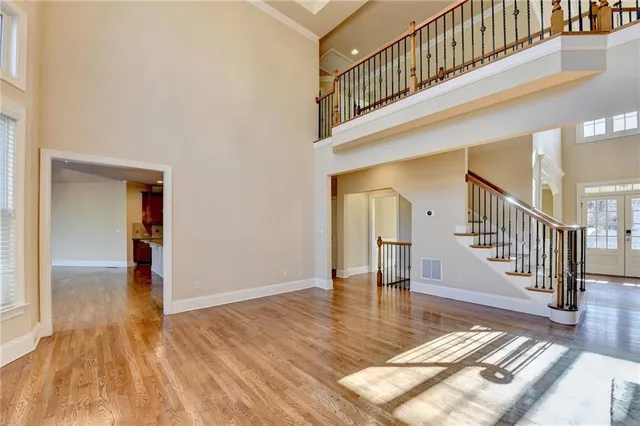 a large kitchen with stainless steel appliances kitchen island granite countertop a refrigerator a stove a sink and a wooden floors