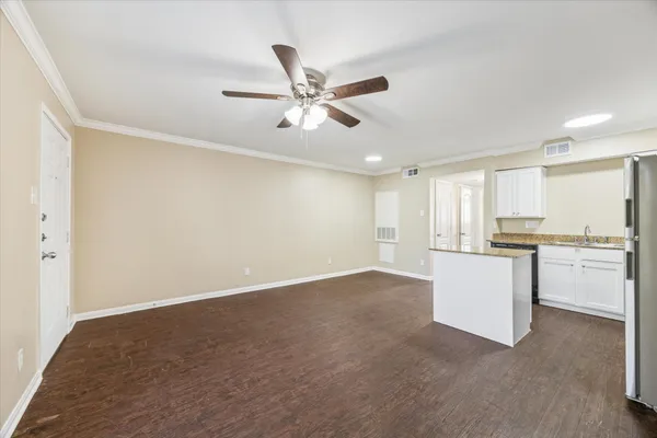 a view of an empty room and kitchen