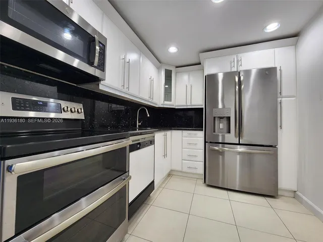 a kitchen with stainless steel appliances and white cabinets