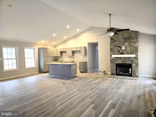 a view of kitchen and empty room with wooden floor kitchen view