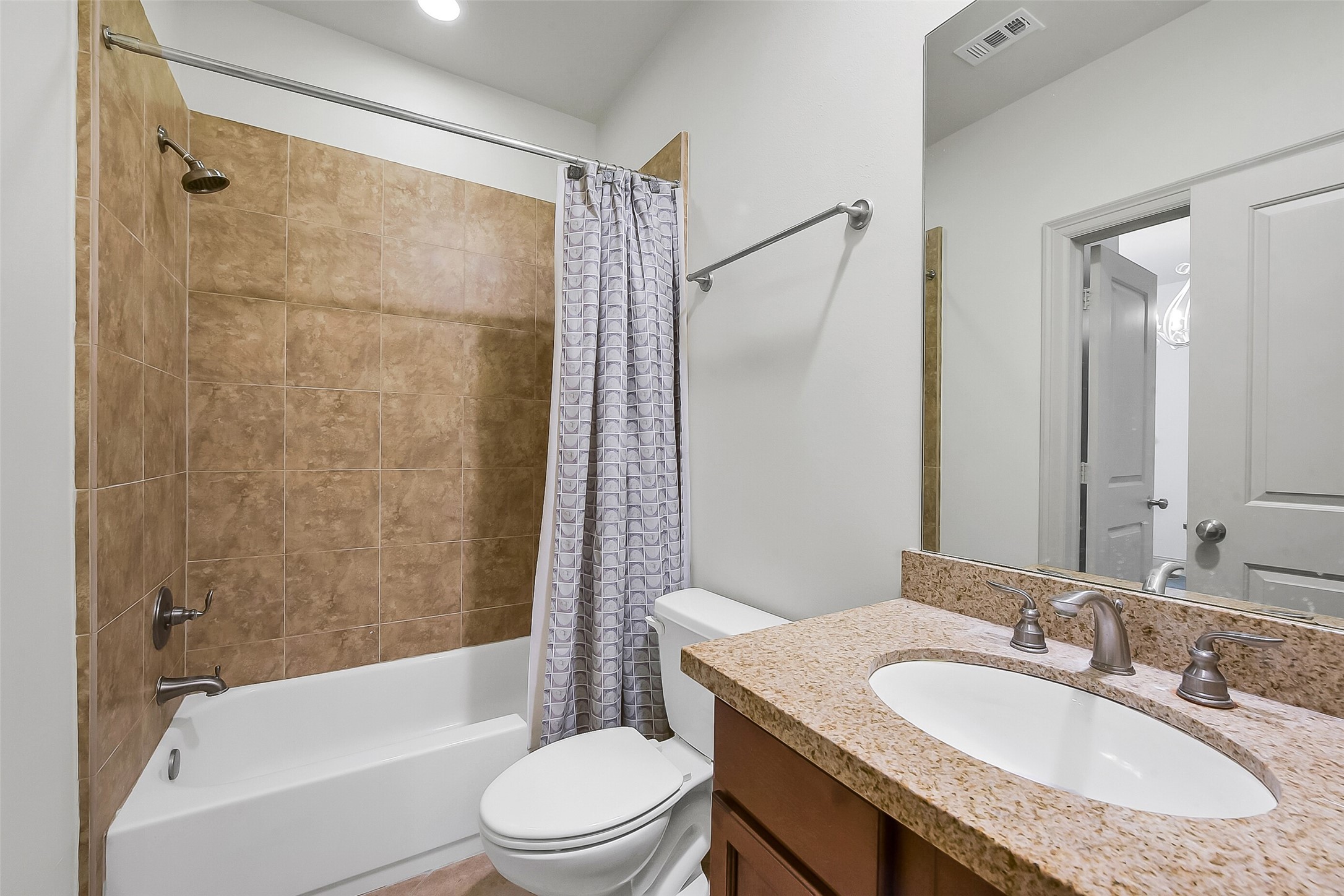 1929 Summer Street Houston, TX 77007 - Photo 21 of 27 En suite bath for secondary bedroom #2 on the first floor features a granite vanity with storage, closet and a tub/shower combination with tile surround.