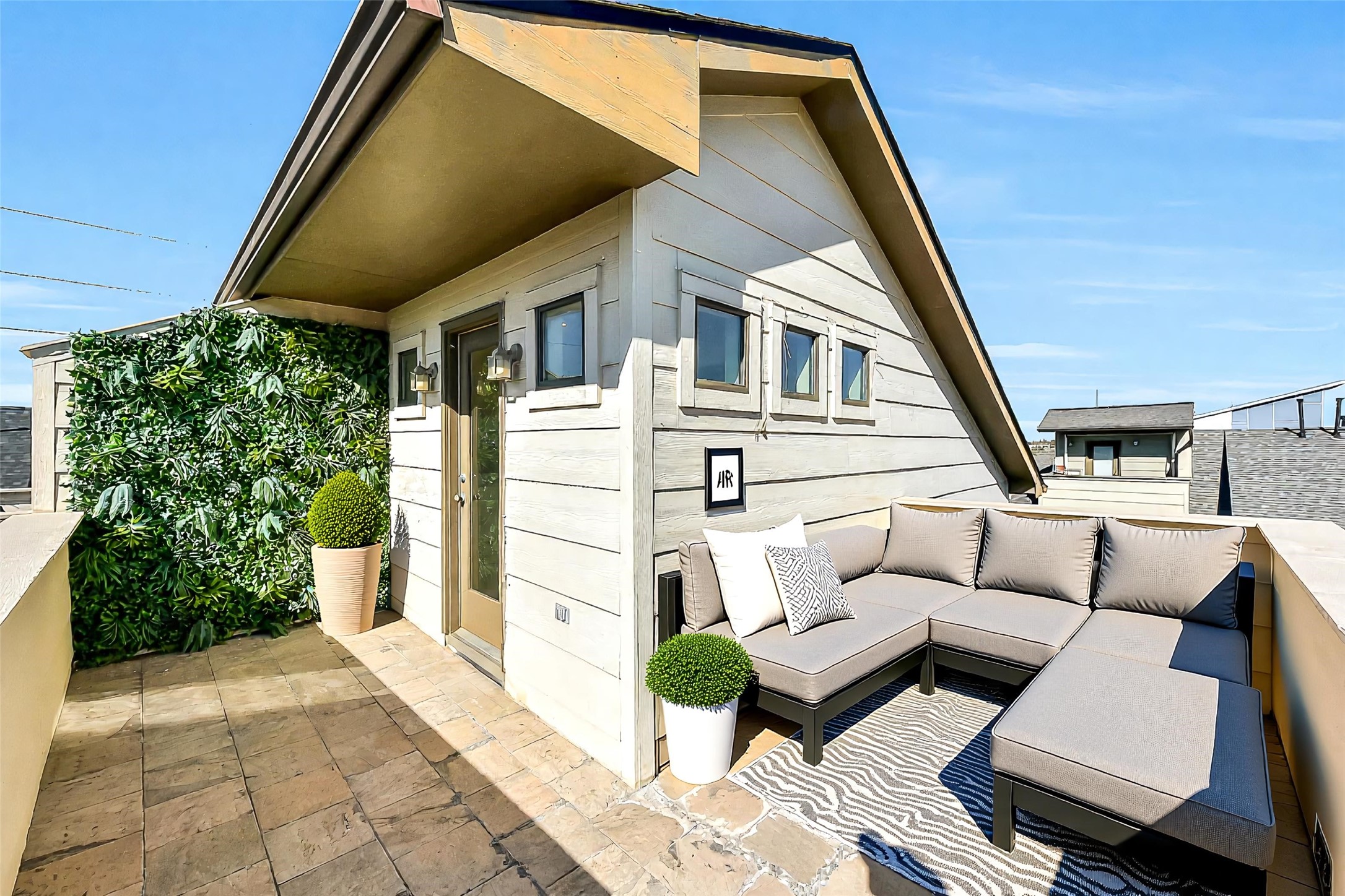 1929 Summer Street Houston, TX 77007 - Photo 24 of 27 Another view of the rooftop terrace highlighting the generous footprint and thoughtful details including an artificial green accent wall and a water spout for easy cleaning. Enjoy sweeping city views, fresh air, and space to dine or lounge under the stars. The furniture in this photo is virtually staged.