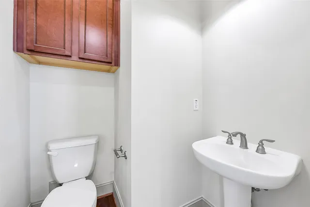 a bathroom with a toilet sink and mirror