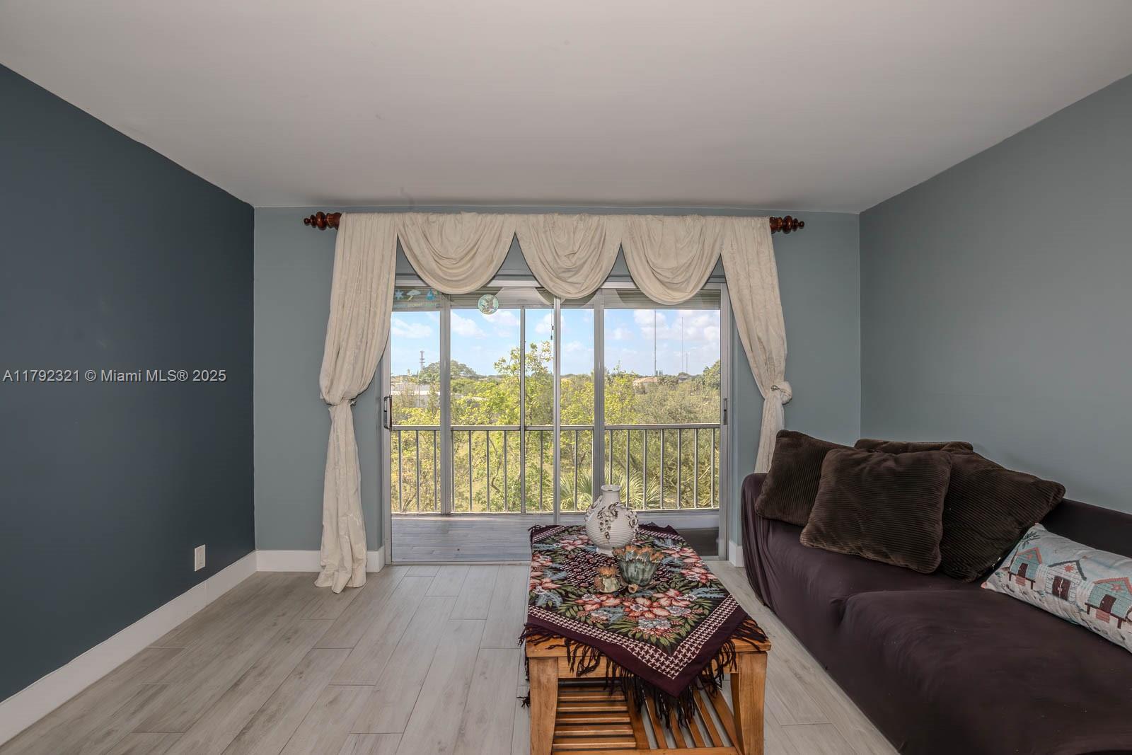 950 Hillcrest Drive, Unit 414 Hollywood, FL 33021 - Photo 14 of 51 a living room with furniture and a large window