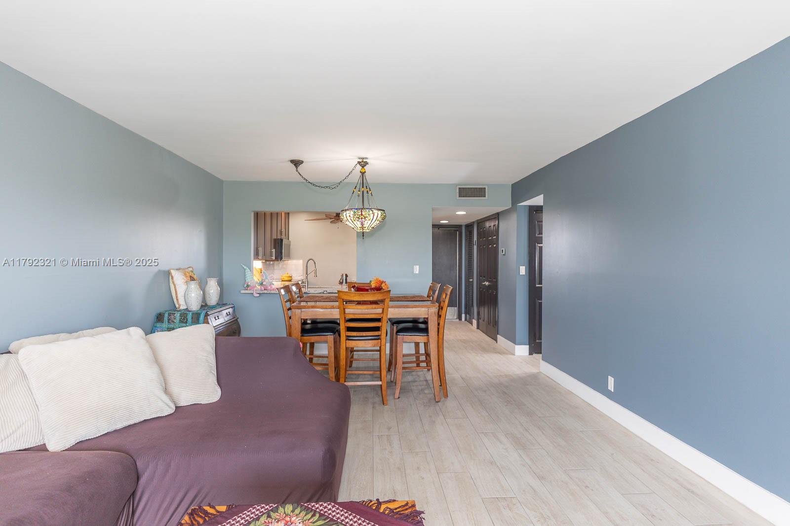 950 Hillcrest Drive, Unit 414 Hollywood, FL 33021 - Photo 19 of 51 a living room with furniture and a dining table with wooden floor