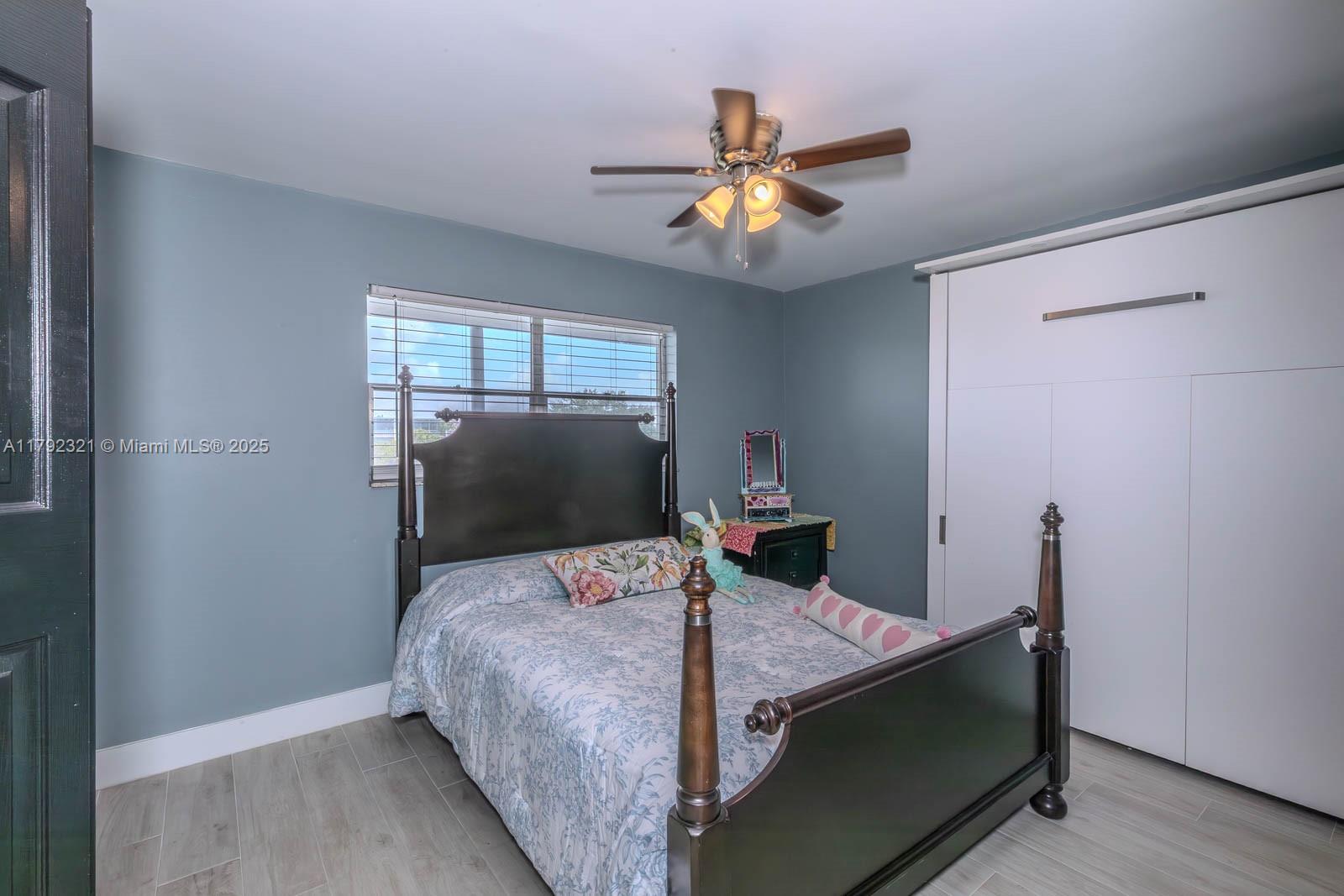 950 Hillcrest Drive, Unit 414 Hollywood, FL 33021 - Photo 21 of 51 a bedroom with a bed and a chandelier