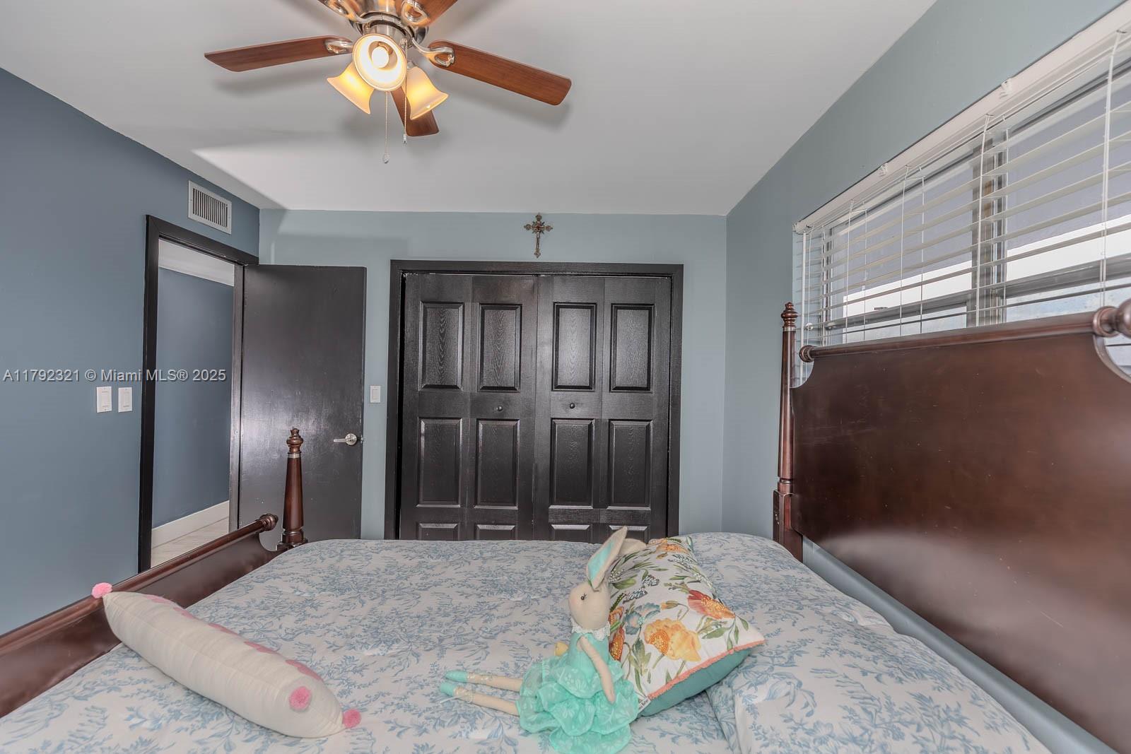 950 Hillcrest Drive, Unit 414 Hollywood, FL 33021 - Photo 23 of 51 a bedroom with a bed and a chandelier