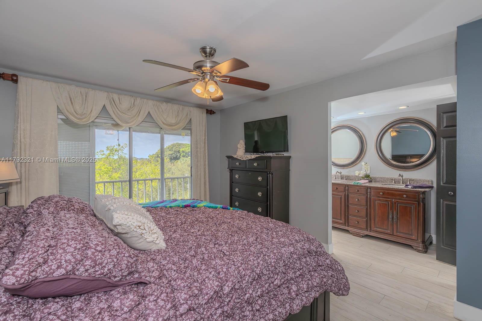 950 Hillcrest Drive, Unit 414 Hollywood, FL 33021 - Photo 30 of 51 a bedroom with a bed a chandelier and dresser