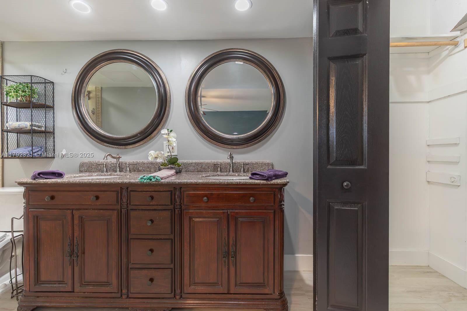 950 Hillcrest Drive, Unit 414 Hollywood, FL 33021 - Photo 33 of 51 a bathroom with a granite countertop double vanity sink and a mirror