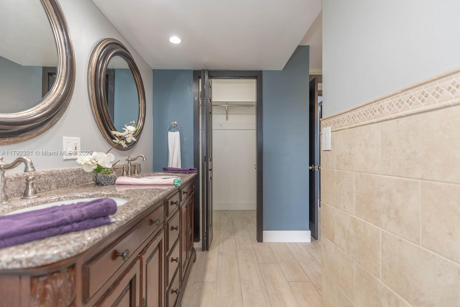 950 Hillcrest Drive, Unit 414 Hollywood, FL 33021 - Photo 36 of 51 a bathroom with a granite countertop double vanity sink and a mirror