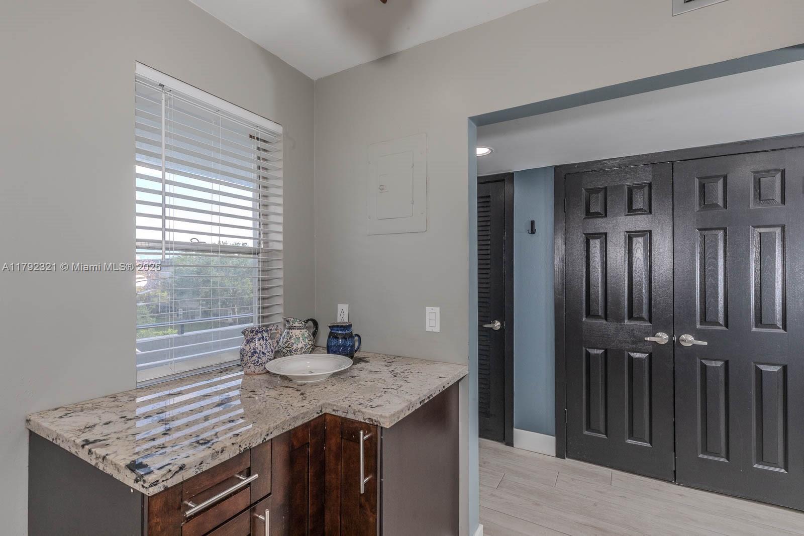 950 Hillcrest Drive, Unit 414 Hollywood, FL 33021 - Photo 7 of 51 a kitchen with granite countertop cabinets and wooden floor