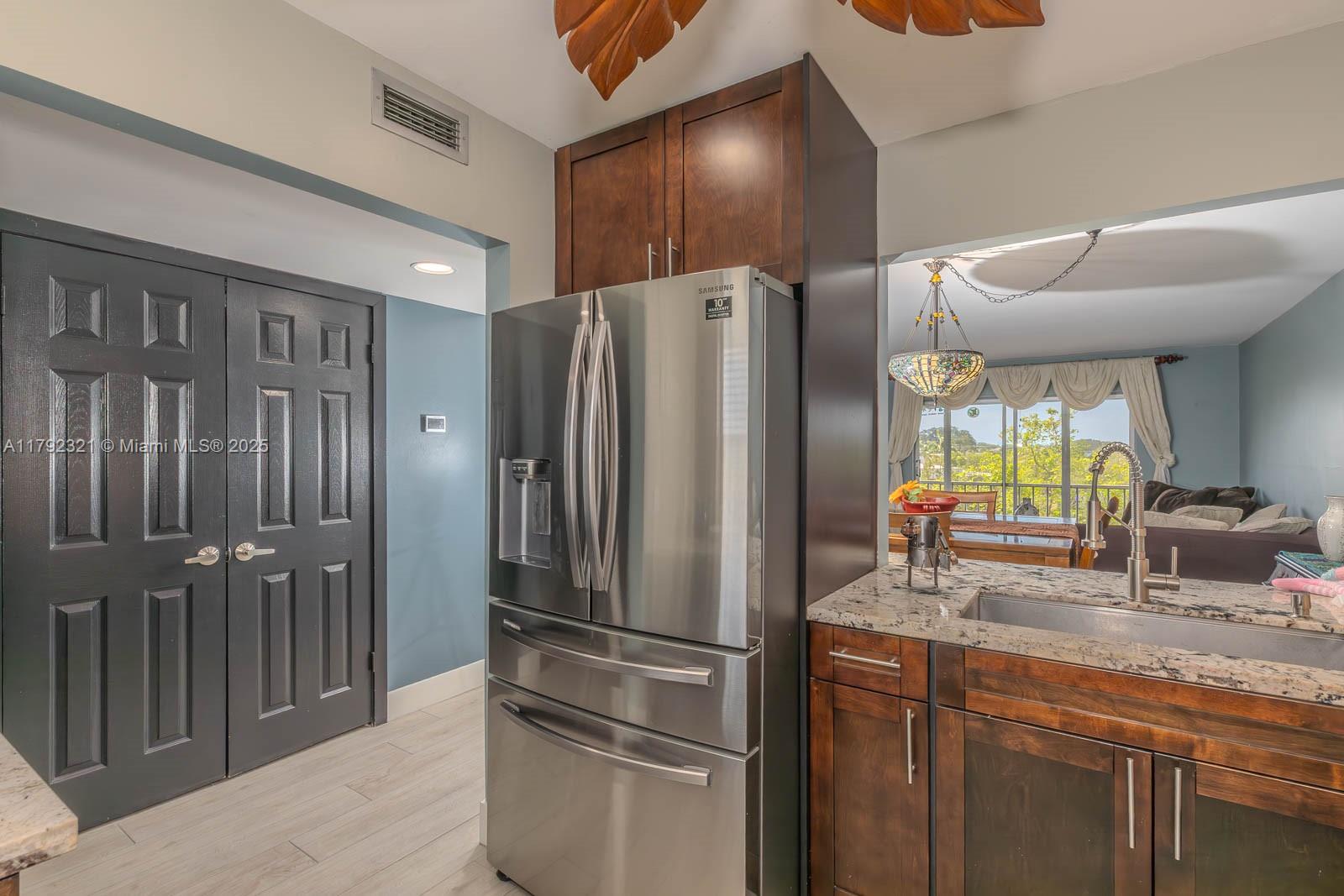 950 Hillcrest Drive, Unit 414 Hollywood, FL 33021 - Photo 8 of 51 a kitchen with stainless steel appliances granite countertop a refrigerator and a sink