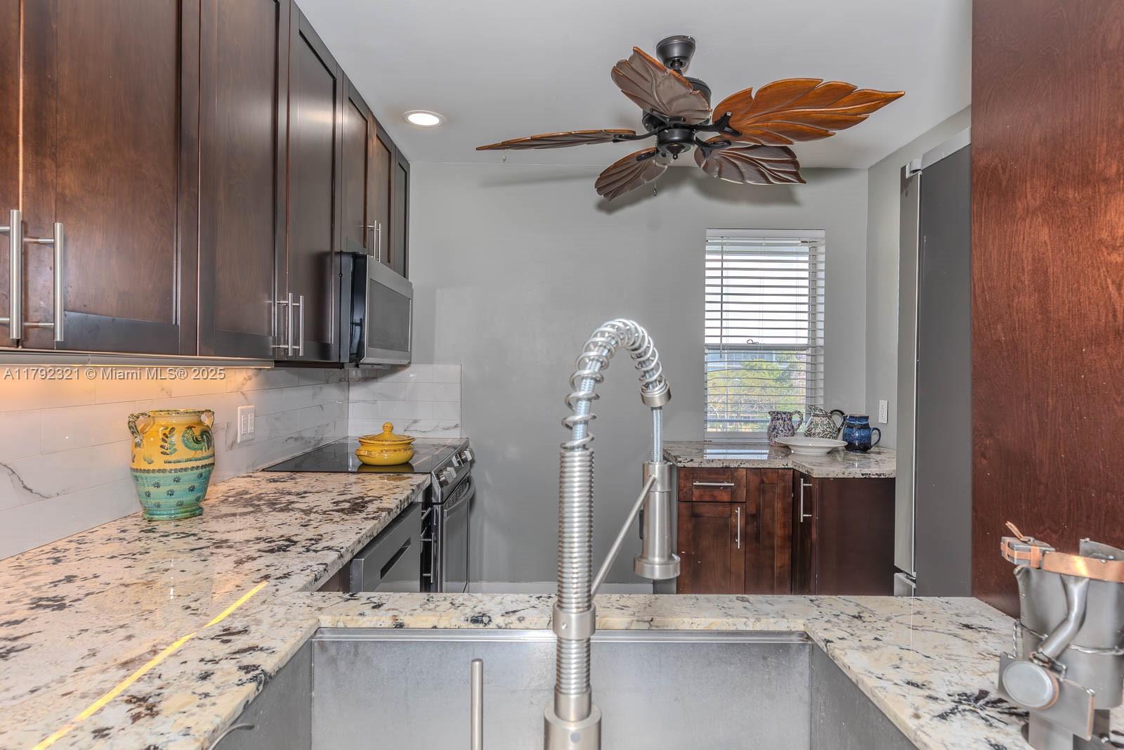 950 Hillcrest Drive, Unit 414 Hollywood, FL 33021 - Photo 10 of 51 a kitchen with stainless steel appliances granite countertop a sink a stove and a wooden floors