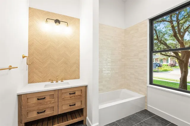 a bathroom with a tub sink and mirror
