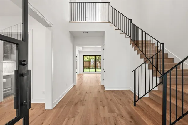 a view of staircase with wooden floor and white walls