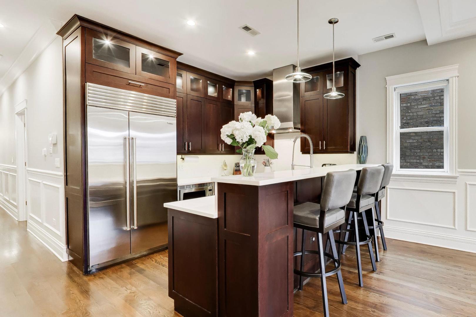 2680 North Orchard Street, Unit 3 Chicago, IL 60614 - Photo 6 of 26 a kitchen with stainless steel appliances kitchen island granite countertop a dining table chairs and a refrigerator