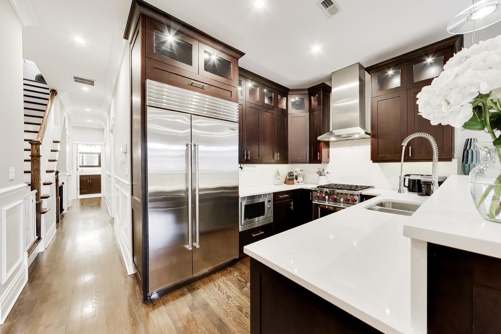 2680 North Orchard Street, Unit 3 Chicago, IL 60614 - Photo 7 of 26 a kitchen with stainless steel appliances kitchen island granite countertop a refrigerator a sink and wooden cabinets