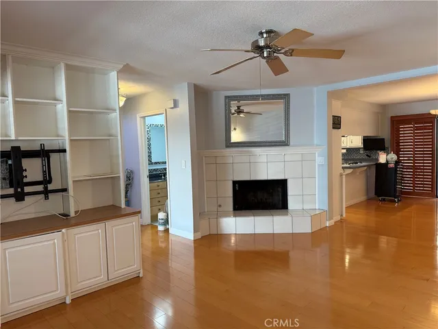 a living room with stainless steel appliances kitchen island granite countertop furniture and a fireplace