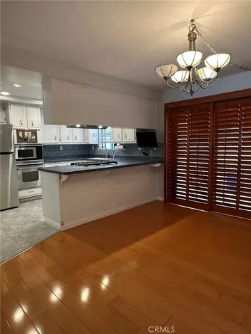 a kitchen with stainless steel appliances granite countertop a sink cabinets and wooden floor