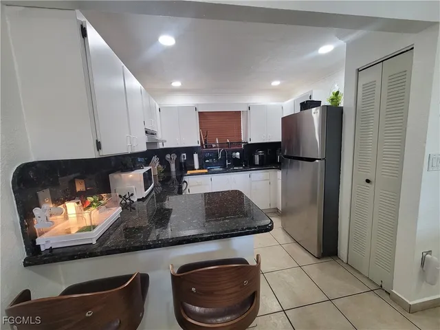 a kitchen with stainless steel appliances granite countertop a refrigerator and a stove top oven