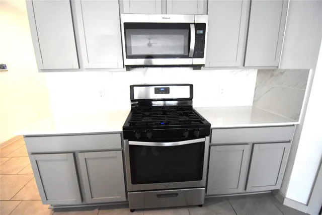 a kitchen with granite countertop white cabinets and stainless steel appliances