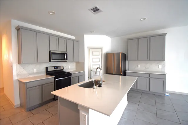 a kitchen with stainless steel appliances a microwave sink and cabinets