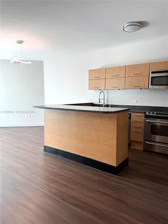 a kitchen with stainless steel appliances granite countertop a sink and a refrigerator